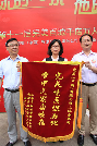 上海市血液管理办公室朱跃国主任（左一）、黄浦区卫生计生委李时珍副主任（右一）向上海分公司颁发锦旗