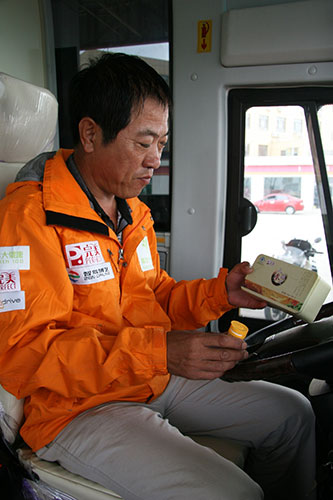 滴丸在口 - 疲劳立走 - 长途跋涉过车程中，车队医疗车司机52岁的奚师傅用人参滴丸提神醒脑